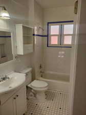 Full bathroom featuring tile patterned flooring, toilet, tiled shower / bath, and vanity