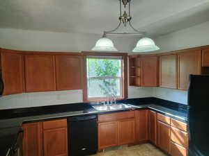 Kitchen featuring black appliances, sink, and light tile patterned floors