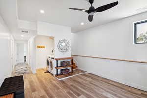 Interior space with washer and clothes dryer, light wood-type flooring, and ceiling fan