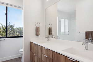 Bathroom featuring vanity, toilet, hardwood / wood-style floors, and a shower with shower door