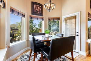 Dining room with a healthy amount of sunlight, a notable chandelier, and light wood-type flooring