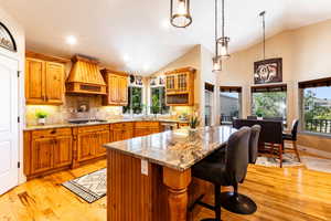 Kitchen with a kitchen bar, a healthy amount of sunlight and premium range hood