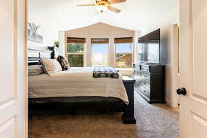 Primary bedroom with vaulted ceiling and ceiling fan