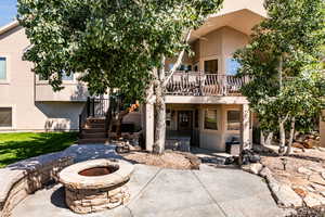 Rear view of property featuring a deck, a patio, and an outdoor fire pit