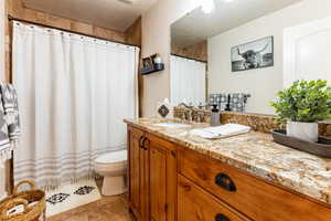 Full Bathroom with vanity, toilet, walk in shower, and tile patterned floors