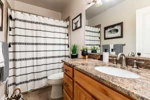 Bathroom featuring tile patterned floors, a shower with shower curtain, toilet, and vanity