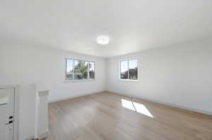 Unfurnished room with a textured ceiling and light hardwood / wood-style flooring