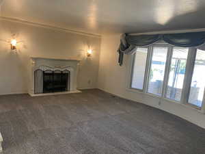 Unfurnished living room with carpet and ornamental molding