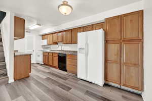 Kitchen with stone counters, sink, light , and white appliances