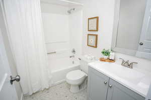 Full bathroom featuring vanity, toilet, tile patterned floors, and shower / bath combo with shower curtain