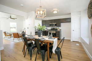 Dining room featuring ceiling fan with notable chandelier and light hardwood / wood-style floors