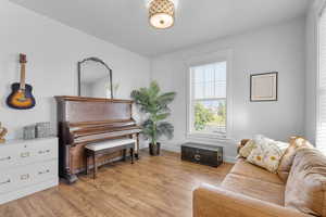 Living room with light wood-type flooring and vaulted ceiling