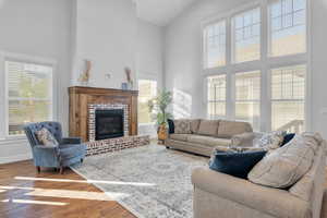 Living room with a high ceiling, hardwood / wood-style flooring, and a wealth of natural light