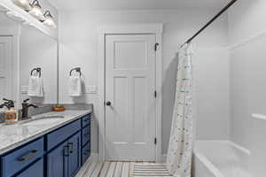 Bathroom featuring shower / bath combo with shower curtain and vanity