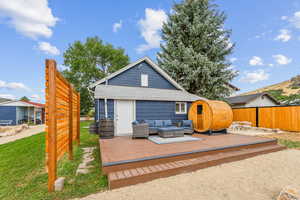 Rear view of property with an outdoor hangout area, a deck, and a lawn