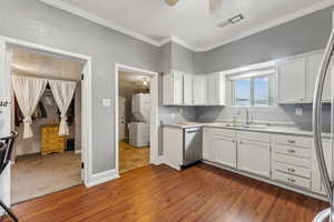 Kitchen featuring dark wood-type flooring, stainless steel appliances, sink, white cabinetry, and ceiling fan