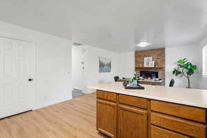 Kitchen with a fireplace and light wood-type flooring