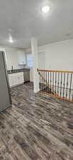 Corridor featuring dark hardwood / wood-style floors, sink, and a textured ceiling