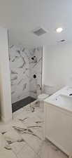 Bathroom featuring toilet, a tile shower, a textured ceiling, and vanity