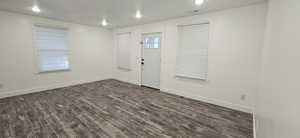 Foyer entrance featuring dark wood-type flooring and a textured ceiling