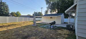 View of yard featuring central AC unit, a patio area, and an outdoor structure