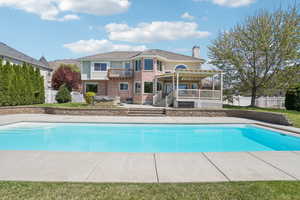 View of swimming pool featuring a fenced in pool, a pergola, fence, a wooden deck, and a patio area