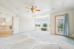 Unfurnished bedroom featuring light carpet, visible vents, access to outside, and multiple windows