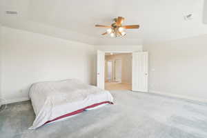 Bedroom with baseboards, a ceiling fan, visible vents, and light colored carpet