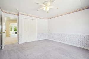 Unfurnished bedroom with ceiling fan, baseboards, carpet flooring, and a closet