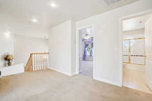 Carpeted spare room featuring recessed lighting, visible vents, and baseboards