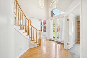 Foyer featuring hardwood / wood-style floors, baseboards, and stairs