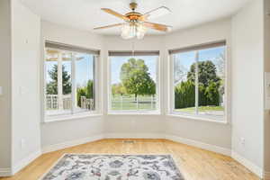 Interior space with light wood-style flooring, visible vents, a ceiling fan, and baseboards