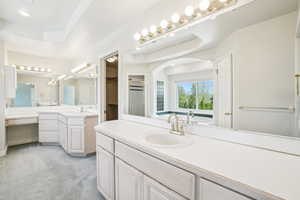 Full bath with two vanities, a sink, and a stall shower