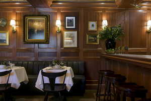 Dining space with ornamental molding and wooden walls