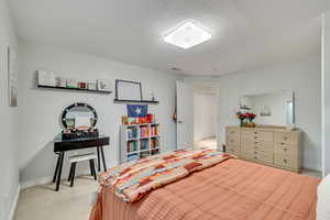 Bedroom featuring a textured ceiling and carpet floors