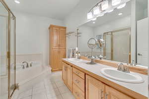 Bathroom with plus walk in shower, tile patterned flooring, and vanity