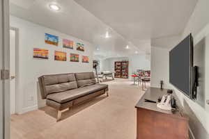 Living room with a textured ceiling and light colored carpet