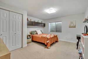 Carpeted bedroom featuring a closet