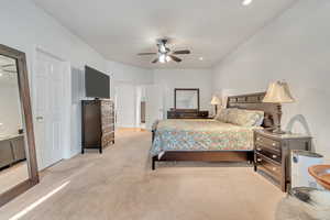 Carpeted bedroom featuring ceiling fan