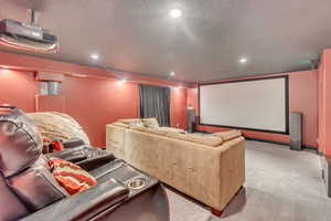 Home theater featuring a textured ceiling and carpet floors