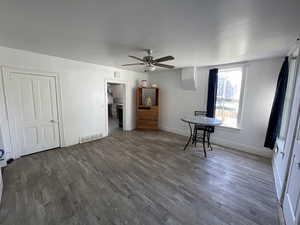 Spare room with ceiling fan and dark wood-type flooring