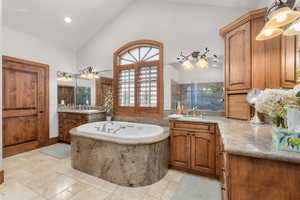 Bathroom with high vaulted ceiling, shower with separate bathtub, and vanity