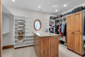 Spacious closet featuring light colored carpet