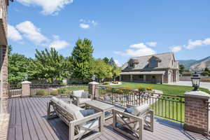 Deck featuring a mountain view, an outdoor living space, and a lawn