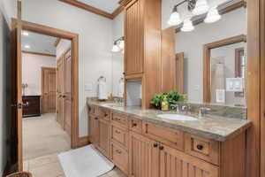 Bathroom with crown molding, vanity, and tile patterned floors