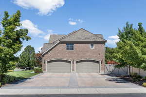 View of side of home with a garage and a lawn