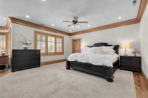 Bedroom with ceiling fan, ornamental molding, and light wood-type flooring