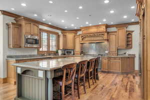 Kitchen featuring a kitchen island, a breakfast bar area, light wood-type flooring, and stainless steel microwave