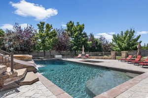 View of swimming pool with pool water feature and a patio area