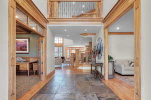 Entryway featuring ornamental molding, a towering ceiling, and wood-type flooring